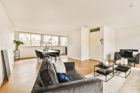 a living room with couch, coffee table and tv in the center of the room there is a large window that...