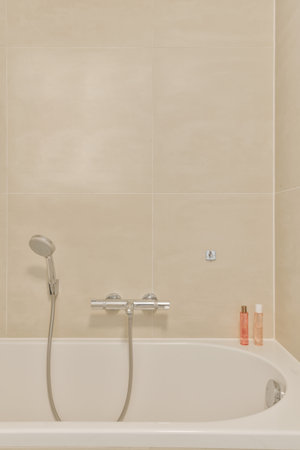 a bathtub in the corner of a bathroom with a shower head and hand held on its arm