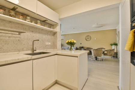 a kitchen with white cabinets and marble counter tops on the wall behind it is an open shelving area...