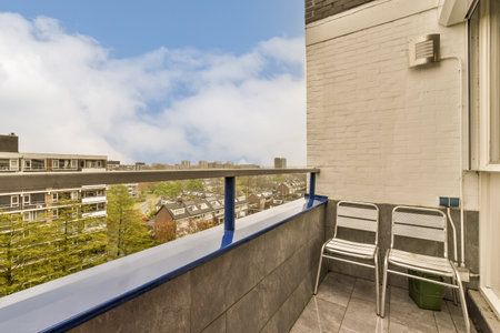 a balcony with some chairs and trees in the foreground, taken from an apartment buildings roof...