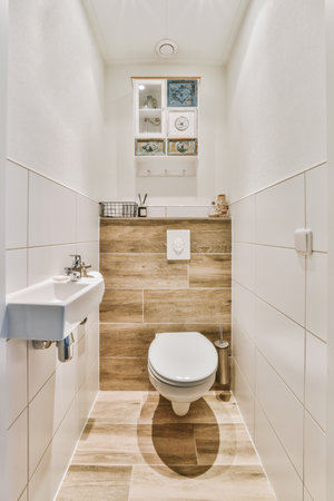 a toilet in a bathroom with wood paneled walls and white tiles on the floor, along with a sink