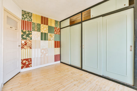 an empty room with wooden floors and colorful wallpapers on the walls, along with two white closet...
