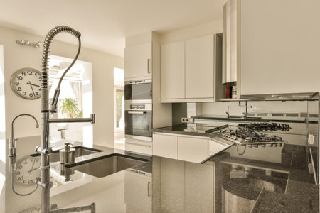 a kitchen with a clock on the counter and an oven in the back ground next to the sink is whiteの写真素材