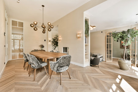a dining room with wood flooring and white walls, an open door to the living room is in the...
