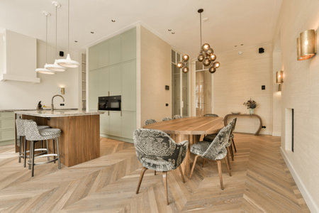a kitchen and dining area in a modern style apartment with wood flooring, white walls and light...