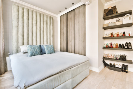 a bedroom with a bed, shelves and shoes on the wall behind it that is made to look like shelvings