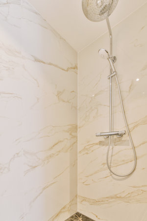 a bathroom with marble walls and white tiles on the floor, along with a shower head mounted to the...