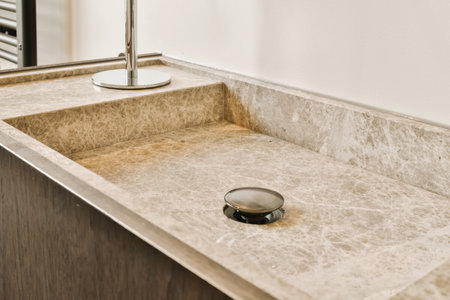 a bathroom sink with a soap dish on the counter next to it and a towel rack in the corner behindの写真素材