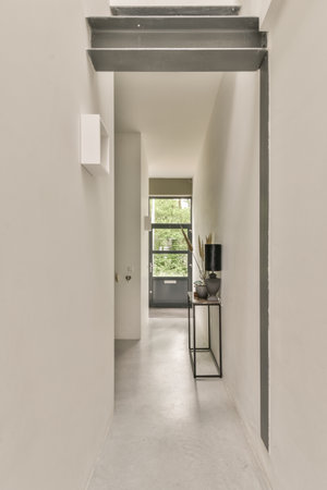 an empty room with white walls and grey trim on the wall, there is a small desk in the corner