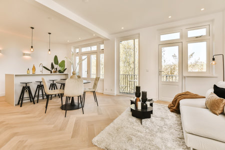 a living room with hardwood flooring and white furniture in the center of the room is an open dining...