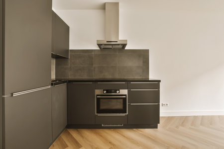 a modern kitchen with wood flooring and black appliances on the stove hood in the oven is built into...