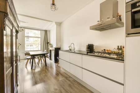 a kitchen and dining area in a small apartment with white cabinets, wood flooring and an open door...