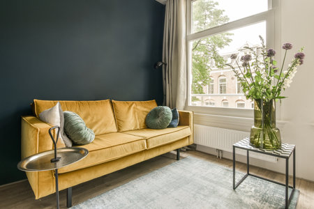 a living room with a yellow couch and two vases on the coffee table next to the sofa is in front of...
