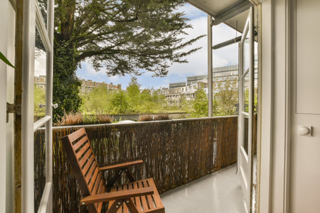 an outside area with a bench and tree in the fore - image is taken from inside, but no one can see itの写真素材