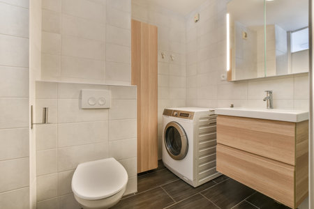 a laundry room with a washer and dryer in the corner next to the toilet bowl on the floorの写真素材