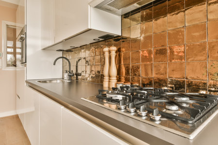 a kitchen with copper tiles on the wall and stoves in the middle part of the room, which is being used for cookingの写真素材