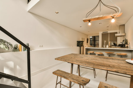 a kitchen and dining area in a house with white walls, hardwood flooring and an open staircase...