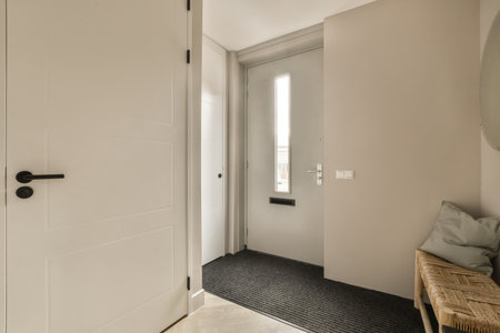 a white door in a room with black carpeting and a mirror on the wall next to the door is a wooden...