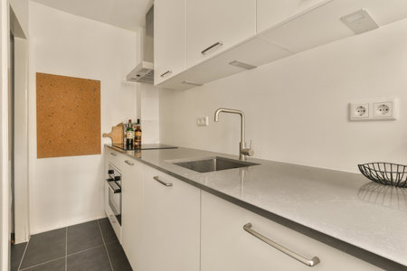 a kitchen with white cabinets and black counter tops on the counters in front of the sink is an...