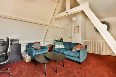 a living room with two couches and a coffee table in front of an attic - style home office spaceの写真素材