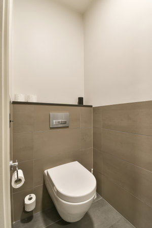 a toilet in the corner of a bathroom with tile on the floor and walls, its all white