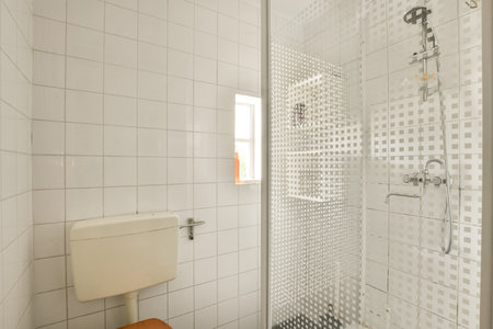 a bathroom with white tiles on the walls, and a toilet in the shower stall door is open to show how...