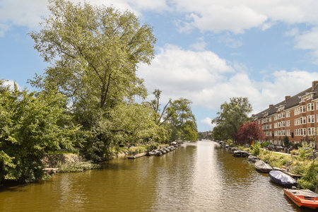 a canal with boats and houses on the other sides in the photo is taken from the bridge over the waterの写真素材