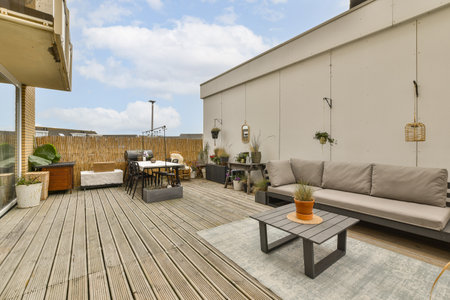 an outdoor living area with wood flooring and wooden furniture on the outside deck looking out to...