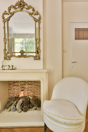 a living room with a fireplace in the center and a mirror on the wall above it that has been paintedの写真素材