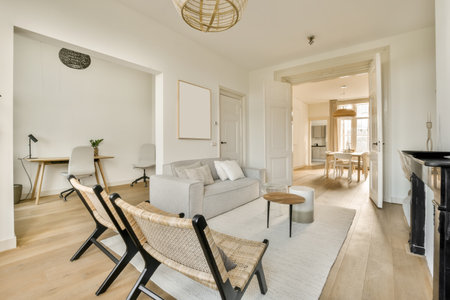 a living room with white walls and wood flooring there is a grey couch in front of the gray sofa