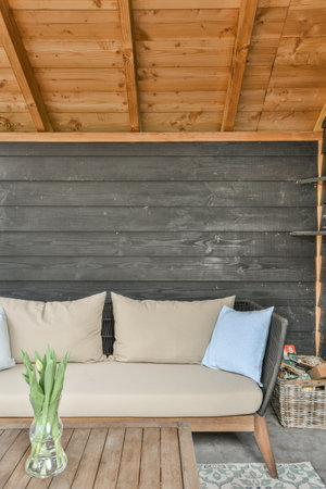 a living room with wood paneled walls and wooden flooring that has been used as an outdoor seating...