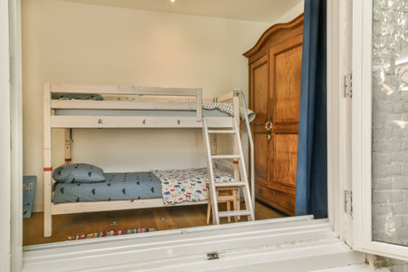 a childs room with bunks in the corner and a window to the right, showing an outside viewの写真素材