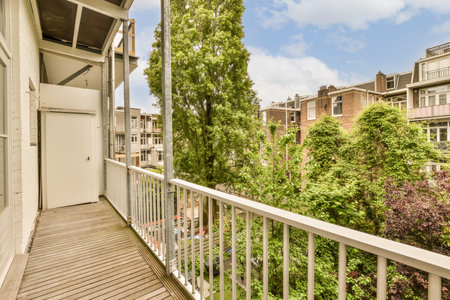 a balcony with trees and buildings in the background, taken from an apartment window looking out onto one of the streetの写真素材
