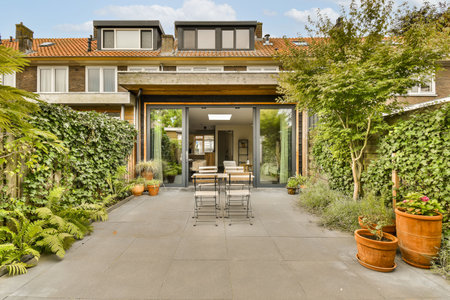 an outdoor dining area with plants and pots on the patio in front of a modern home surrounded by...