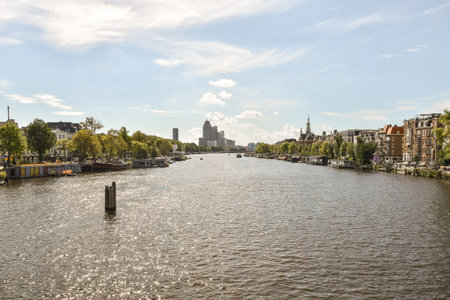 a river with houses and boats in the fore, taken from a boat on the other side of the waterの写真素材
