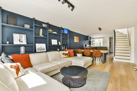 A contemporary living space featuring a cozy sofa, stylish decor, and a modern kitchen view. The...