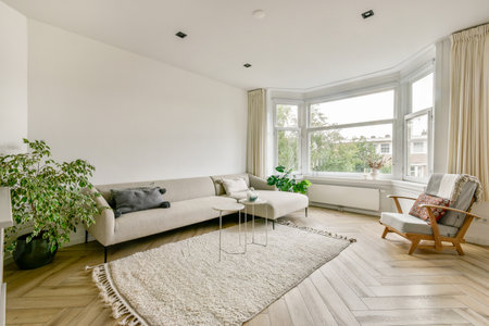 A stylish modern living room featuring a neutral color palette, a cozy sofa, and a touch of greenery...
