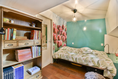 A bright, inviting bedroom featuring a bed adorned with floral bedding, a wooden shelf filled with...