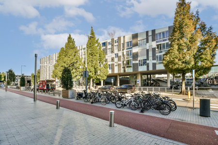 A contemporary urban structure featuring large windows and greenery, with a dedicated bicycle...