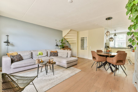 Cozy modern living room featuring a stylish gray sofa, elegant decor, and a blend of natural light...