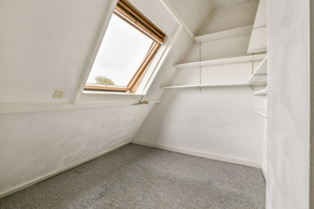 A bright, minimalist interior space featuring angled walls and a window, showcasing a clean...