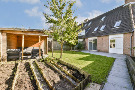A beautifully designed garden featuring a cozy seating area beside vibrant greenery and vegetable...
