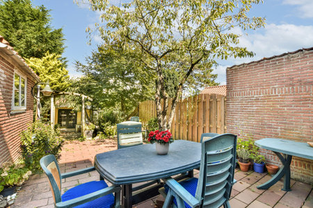 An inviting outdoor patio features a rustic brick wall, a wooden table, comfortable chairs, and...