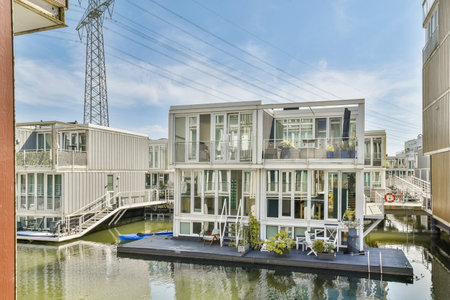 A picturesque view of contemporary floating houses lining a tranquil waterway, showcasing unique architecture and serene surroundings.の写真素材