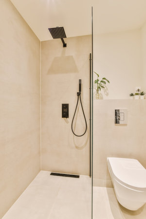 a modern bathroom with white walls and beige flooring, including a walk - in shower stall attached to the wallの写真素材