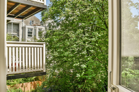 the outside of a house with trees and bushes in front of it, as seen from inside an open window