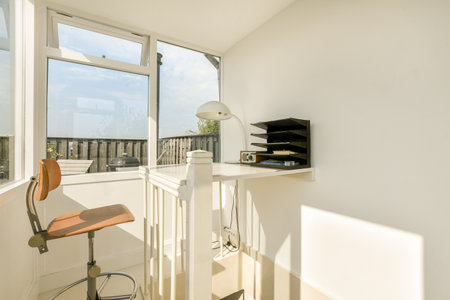Bright and airy home office featuring a sleek desk, stylish chair, and ample natural light, ideal for productivity and creativity.の写真素材