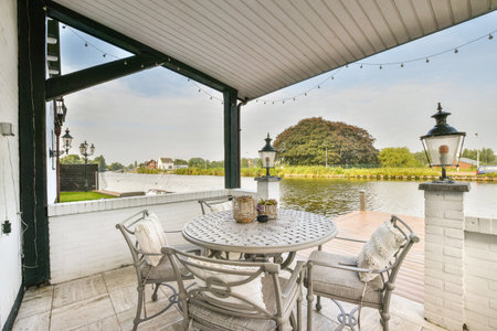 A charming outdoor patio featuring a round table and chairs, surrounded by greenery and looking out...