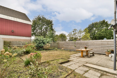 A tranquil garden scene featuring a wooden table and various decorative plants amidst a scenic...