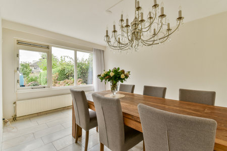 A beautifully designed dining room featuring a wooden table, plush chairs, and an elegant...